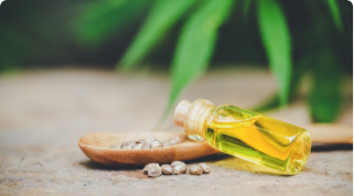 Vial of oil leaning on a wooden spoon